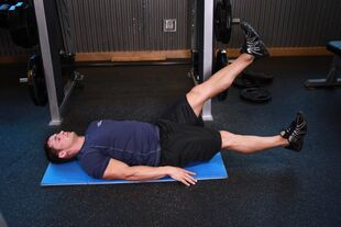 A man with prostatitis is doing an exercise in the gym